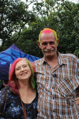 Short woman and tall man with colourful hair