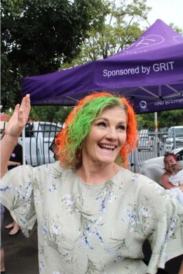 Woman makes a fun pose with green and orange hair