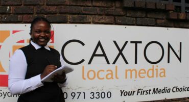 Young women standing in front of a board.