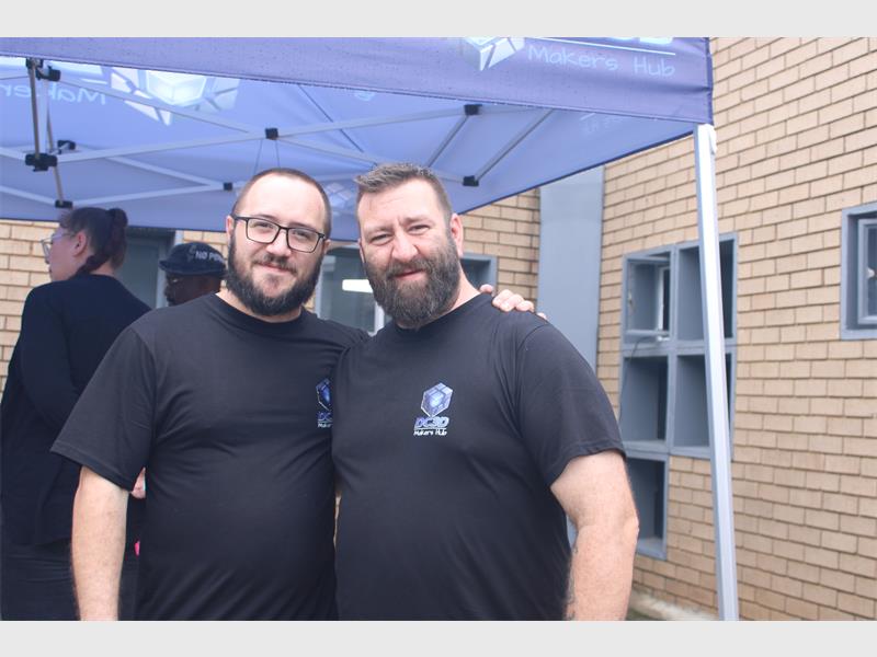 Two men standing next to each other smiling at the camera.