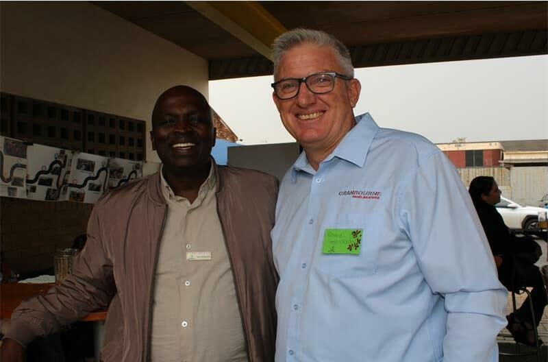 Elderly black and white men smiling at the camera
