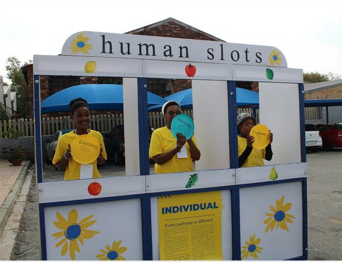 Three black women standing in a carnival game