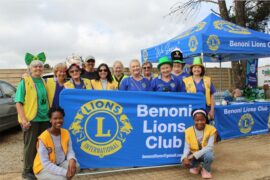 Group of people standing at a Lions banner