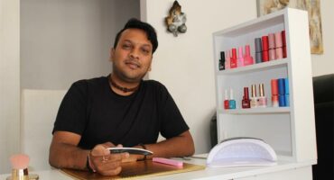 Indian man sitting at a nail table