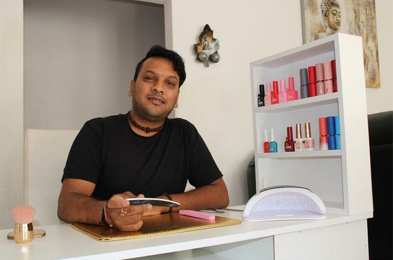 Indian man sitting at a nail table
