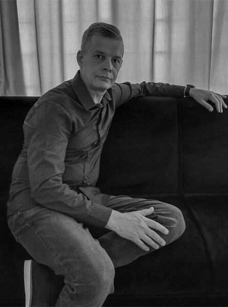 Black and white photo of man sitting on a couch