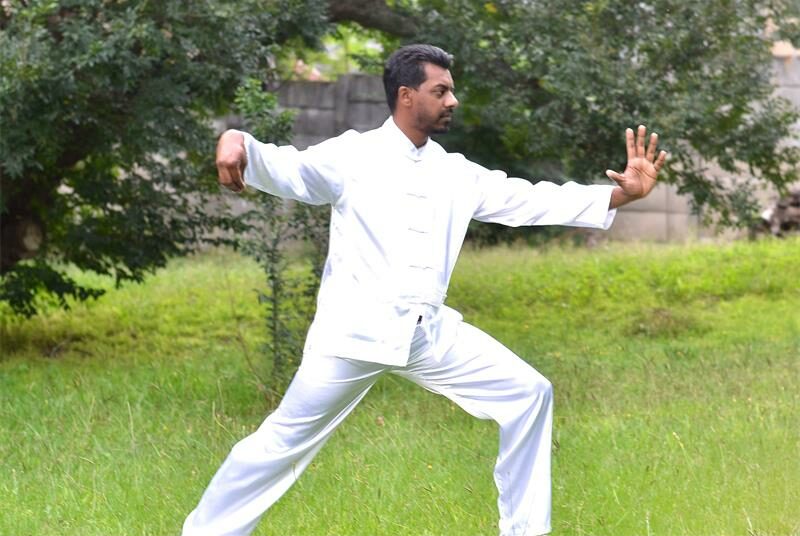 Indian man in white in a posed stance