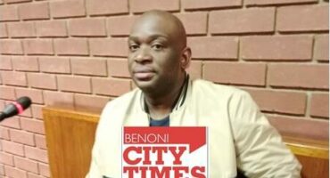 Black man wearing a beige and black jacket