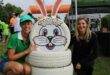 Two woman posing at a bunny display made from tyres.