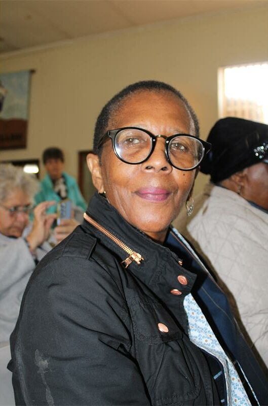Black woman with glasses wearing a black jacket
