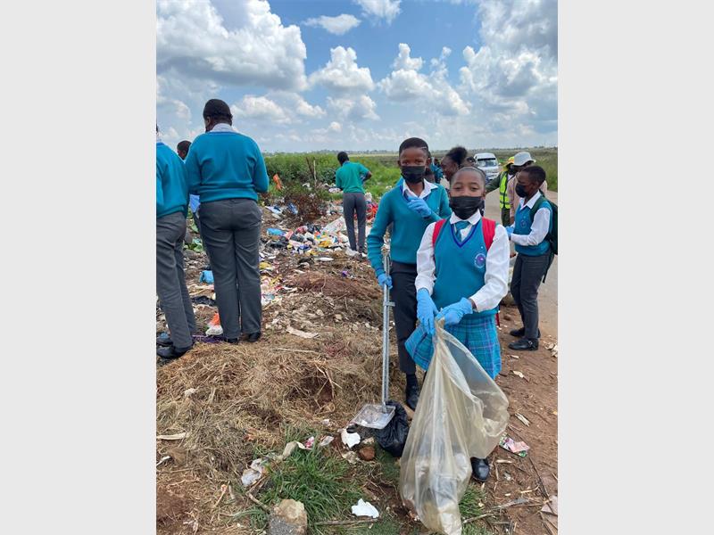 children picking up garbage,wearing school uniform.