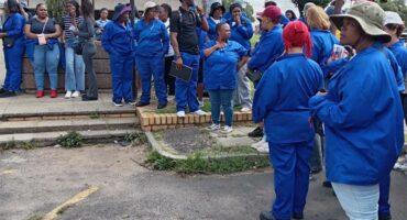 People clad in blue standing in front of a building