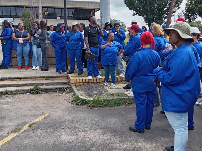 People clad in blue standing in front of a building