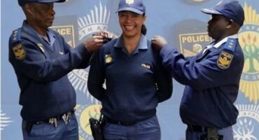 Two male police officers flanking a female officer