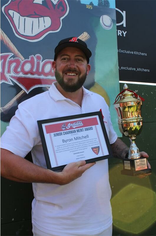 Man with a beard holding a certificate and trophy