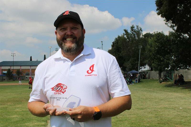 Man with a beard holding a glass trophy