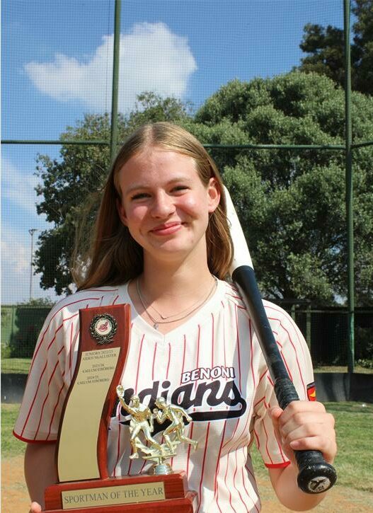 Girl stands with a baseball bat over her shoulder and holding a trophy