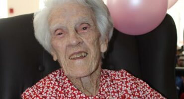 Bejaarde dame glimlag vir die kamera