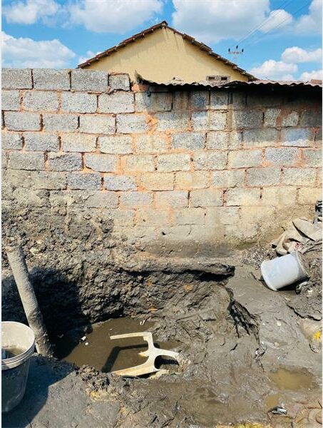 Gray brick wall with hole filled with water