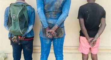 Three black men facing a wall