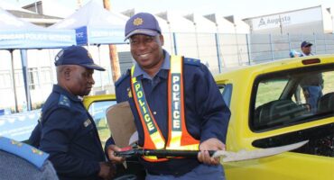 Police officer smiles while holding a spade
