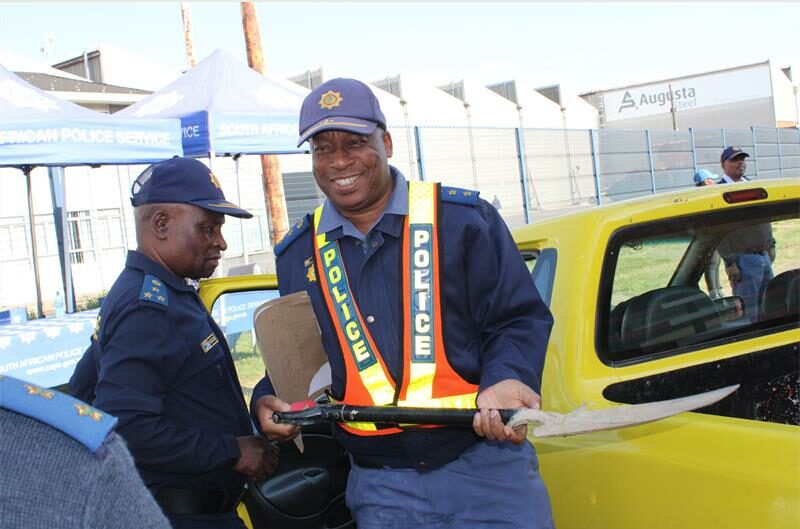 Police officer smiles while holding a spade