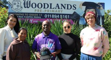 Four women and a man standing in front of a Woodlands school board.