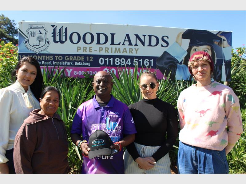 Four women and a man standing in front of a Woodlands school board.