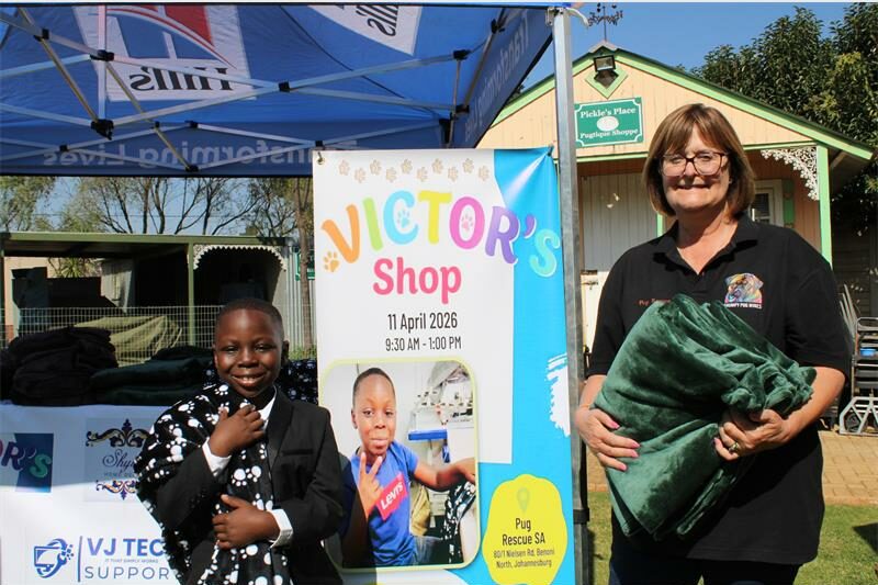 Black boy wearing a suit stands with a blanket next to an older woman
