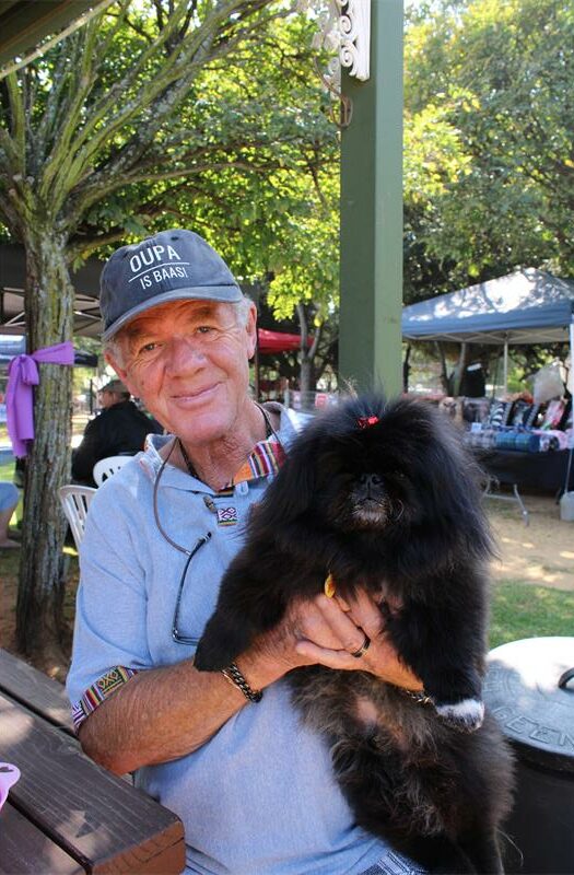 Elderly man holding a fluffy black dog