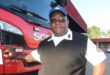 Black man in uniform standing at a fire engine