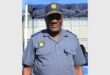 Aman in SAPS uniform smiling.