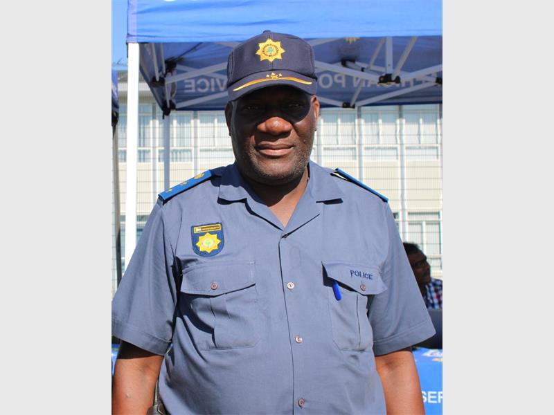 Aman in SAPS uniform smiling.
