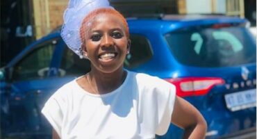 A lady in a white dress smiling at the camera