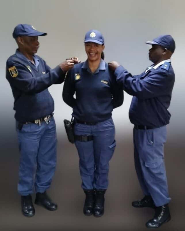 Two male police officers flanking a female officer