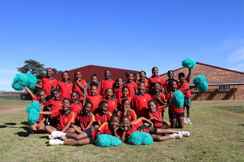 Group of black girls smiling and holding pom-poms