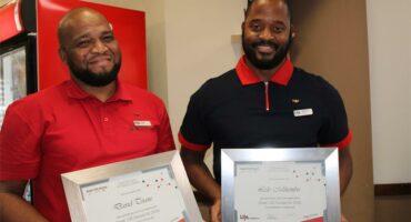 Two black men holding certificates