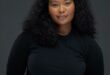 Black woman against a black backdrop