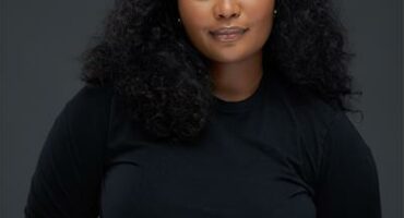Black woman against a black backdrop