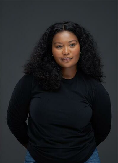 Black woman against a black backdrop