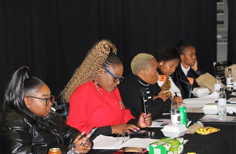 Panel of black women sitting at a table