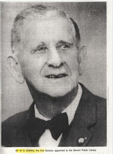A black and white photo of a white elderly man wearing a black suit, white shirt and black bowtie.