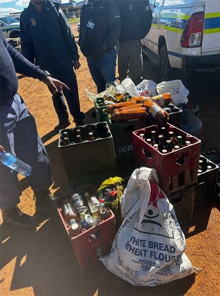 Crates of liquor surrounded by SAPS officers