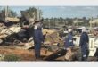 Police next to demolished shacks.