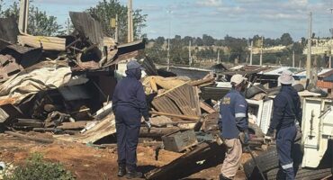 Police next to demolished shacks.