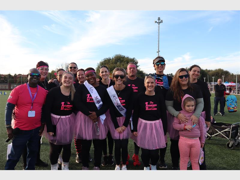 A group of people dressed in black and pink supporting a Cansa Relay for Life.