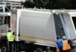 File image of a waste removal truck with men hanging on the sides