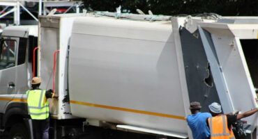 File image of a waste removal truck with men hanging on the sides