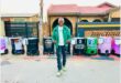 A guy standing in front of colourful hand washing stations.