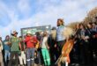 Black man stands in front of a group of protesters wearing traditional Zulu attire